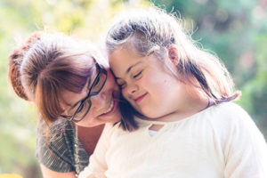 Mother shows love to young girl with developmental disability