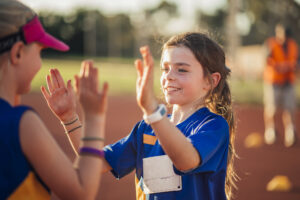 Girl playing sports, receiving high five. 