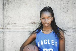 Teen standing with confidently with basketball, good self-esteem. 