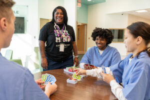youth playing a card game while BHT watches