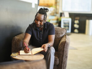 A young man sitting in a coffee shop and working.