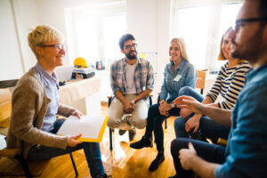 Group of people sitting in a circle- a training is taking place.