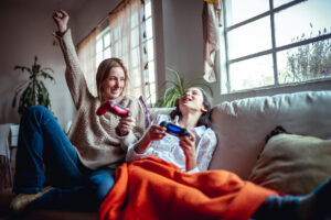 Mother and daughter playing video games. Mommy is winning