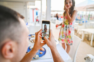 Father photographing daughter with mobile phone. Shari Franke warns of the dangers of sharing children's lives online.