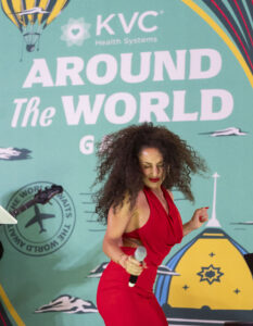 Tayla Groves performs in front of a color KVC Health Systems Around the World Gala backdrop